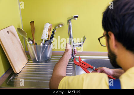 Plumber installazione, riparazione rubinetto di acqua in cucina Foto Stock