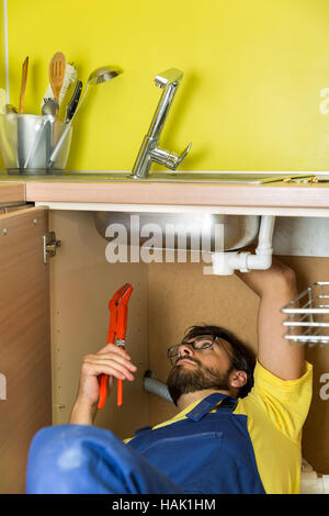 Plumber riparazione rubinetto di acqua sotto lavello da cucina Foto Stock