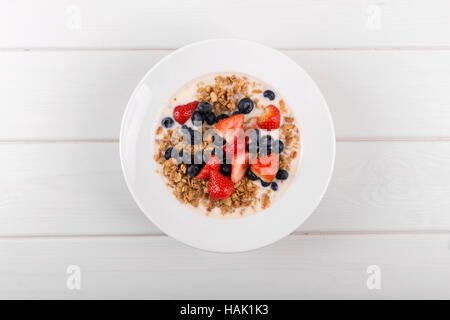 Vista dall'alto di cereali e muesli colazione con yogurt e frutti di bosco freschi Foto Stock