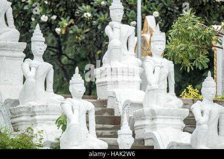 Statue della Pagoda di Sat Taw Yar Mingun Myanmar // MINGUN, Myanmar - la Pagoda di Sat Taw Yar si trova lungo il lungomare del fiume Ayeyarwady nel villaggio di Mingun. La pagoda fa parte della collezione di monumenti religiosi di Mingun situati sulla riva occidentale del fiume Ayeyarwady (noto anche come Irrawaddy). Mingun si trova a circa 11 chilometri a monte di Mandalay ed è accessibile principalmente in barca attraverso il fiume. Il villaggio è noto per la sua incompiuta Mingun Pahtodawgyi, commissionata dal re Bodawpaya alla fine del XVIII secolo, e per la Campana di Mingun, fusa nel 1808. Il lungofiume di Sat Foto Stock