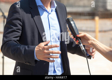 Giornalista rendendo intervista con imprenditore o politico Foto Stock