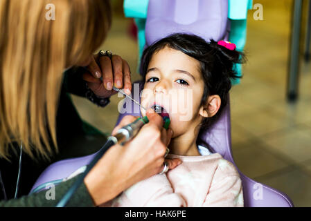 Little Girl getting trattamento dentale in studio dentistico Foto Stock