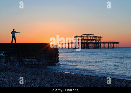 Persona pratica il Tai Chi presso sunrise vicino molo Ovest di Brighton. Foto Stock