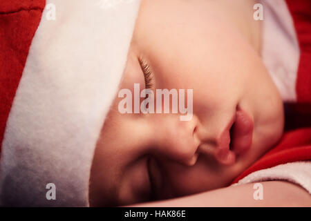 Close up del sonno del bambino faccia in santa outfit Foto Stock