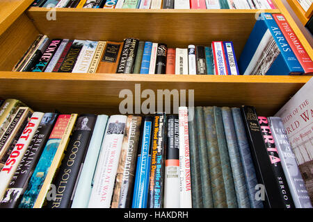 Prenota caso con scaffali di libri in inglese su temi militari, principalmente la seconda guerra mondiale. Hardbacks e rilegati misti. Basso angolo di visione. Foto Stock