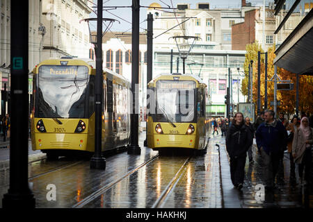 Manchester Piccadilly gardens Metrolink tram strada bagnata dalla pioggia Tram Metrolink light rail pendolari rapida unità di trasporto trasporta moderno vehicl Foto Stock