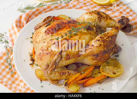 Tutto il pollo arrosto con verdure sulla piastra bianca. Foto Stock