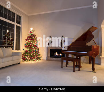 Luminoso albero di Natale in soggiorno con caminetto e pianoforte durante il periodo notturno. Foto Stock