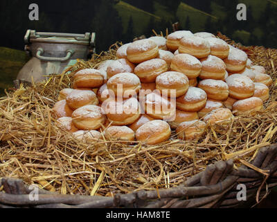 Cumulo di fritto crema bavarese riempito le ciambelle su letto di paglia Foto Stock