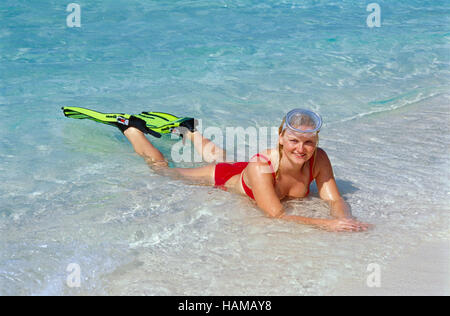 Blonde 20 anno-vecchio donna che indossa le immersioni pinne e maschera che giace nel profondo di acqua oceanica, Summer Island Village, North Male Atoll Foto Stock