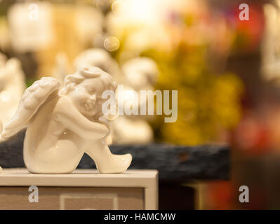 Angelo seduto sul sedile della scatola di figurine di porcellana Foto Stock