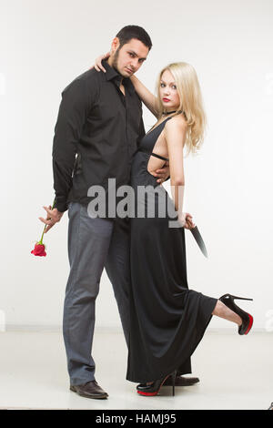 Ragazza con il coltello traditore. l uomo con rosa in mano. Foto Stock