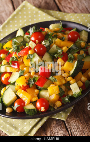 Verdura fresca insalata con mais, pomodori, cetrioli e pepe vicino sul piano verticale. Foto Stock