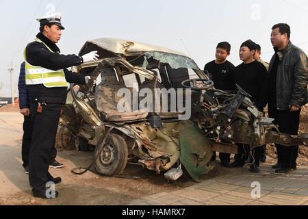 Cangzhou cinese nella provincia di Hebei. 2° dic, 2016. Un poliziotto del traffico mostra una macchina distrutta in un incidente al driver locale durante un evento per contrassegnare il traffico nazionale di sicurezza nel giorno Dongguang County, a nord della Cina di nella provincia di Hebei, Dicembre 2, 2016. © Fu Xinchun/Xinhua/Alamy Live News Foto Stock