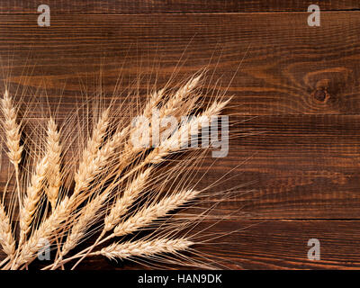 Spikelets di grano su sfondo di legno Foto Stock
