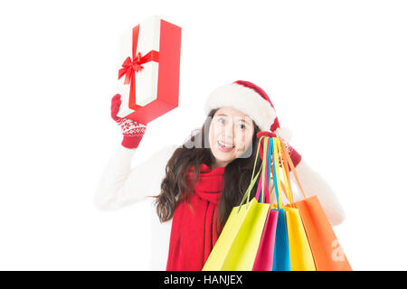 Natale Inverno vendita shopping. La donna a santa hat holding permanente shopping bags eccitato isolati su sfondo bianco. Giovani razza mista cinese asiatica Foto Stock