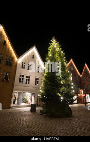 Le luci di Natale a Bryggen edifici commerciali sulla banchina del porto di Vagen, Bergen, Norvegia. Foto Stock