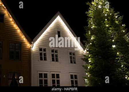 Le luci di Natale a Bryggen edifici commerciali sulla banchina del porto di Vagen, Bergen, Norvegia. Foto Stock