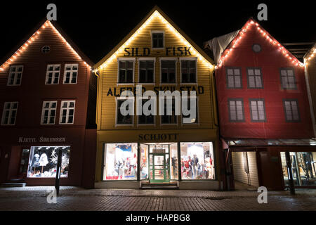 Le luci di Natale a Bryggen edifici commerciali sulla banchina del porto di Vagen, Bergen, Norvegia. Foto Stock