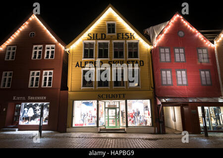 Le luci di Natale a Bryggen edifici commerciali sulla banchina del porto di Vagen, Bergen, Norvegia. Foto Stock