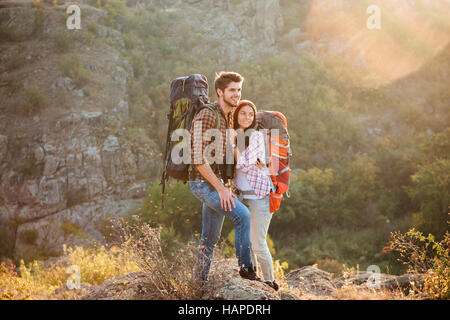 Due turisti con zaini su pendio guarda lontano Foto Stock