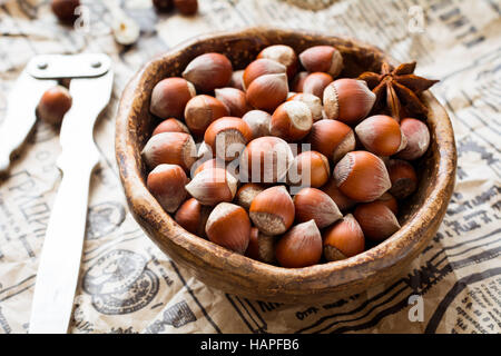 Le nocciole in una ciotola sul vecchio giornale vintage, orizzontale, vista ravvicinata Foto Stock