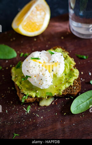 Purea di avocado e Uovo affogato su tostati Pane di segale. Una sana prima colazione, snack sani Foto Stock