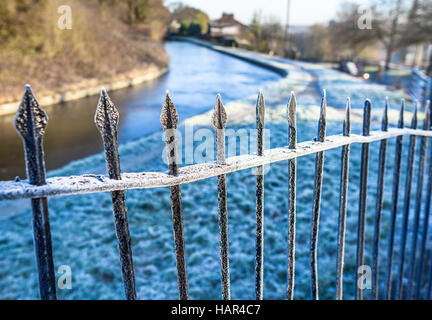 Smerigliati vecchie ringhiere in ferro a fianco di un canale in inverno. Foto Stock