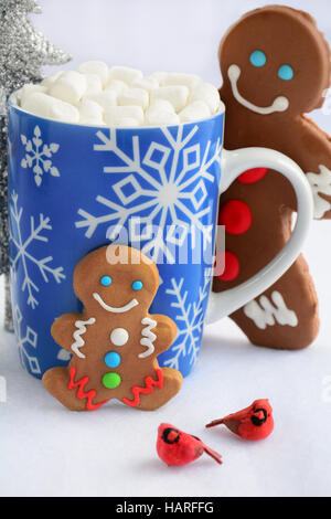 Carino poco decorata gingerbread gli uomini con il simbolo del fiocco di neve la tazza di cioccolata calda e mini marshmallows per un Natale di trattare Foto Stock