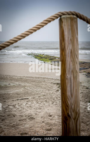 Beach post con fune bannister sulla parte superiore e sulla spiaggia in background, Norderney Isola, Germania, Europa. Foto Stock