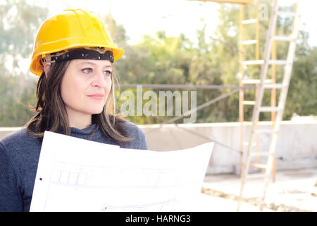 Ritratto di una bella donna architetto presso un cantiere con blueprint. All'esterno. Foto Stock