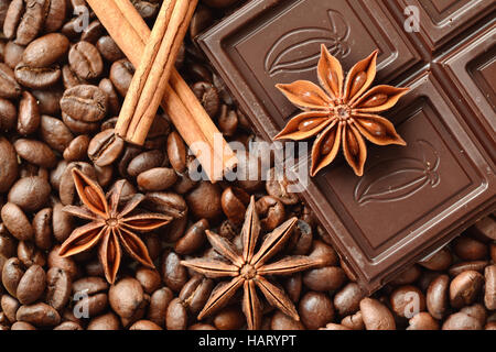 Cioccolato, anice stellato e bastoncini di cannella sul caffè in grani Foto Stock