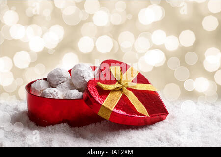 Tradizionali biscotti di Natale con le mandorle in forma di cuore confezione regalo sulla neve Foto Stock