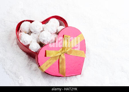 Tradizionali biscotti di Natale con le mandorle in forma di cuore confezione regalo sulla neve Foto Stock