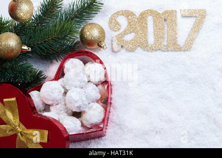 Tradizionali biscotti di Natale con le mandorle in forma di cuore confezione regalo sulla neve Foto Stock