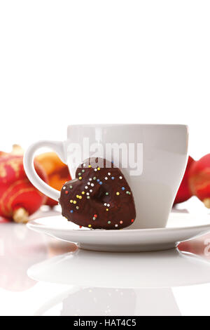 Tazza di caffè e un piccolo a forma di cuore gingerbread cookie e palle di Natale sul retro Foto Stock