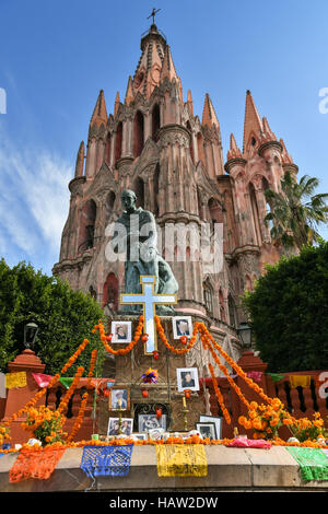 Un altare noto come un ofrenda intorno alla statua della statua di Fray Juan de San Miguel decorato per il Giorno dei Morti festival presso il Jardin Principal in San Miguel De Allende, Guanajuato, Messico. La settimana di festa è un momento in cui i messicani benvenuti i morti alla messa a terra per una visita e celebrare la vita. Foto Stock