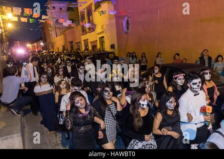 Gli studenti vestiti come la Calavera Catrina per il Giorno dei Morti festival parade attraverso il quartiere storico di San Miguel De Allende, Guanajuato, Messico. La settimana di festa è un momento in cui i messicani benvenuti i morti alla messa a terra per una visita e celebrare la vita. Foto Stock