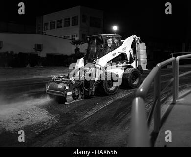 Asfalto macchina fresatrice a lavorare durante la notte, la riparazione della strada Foto Stock