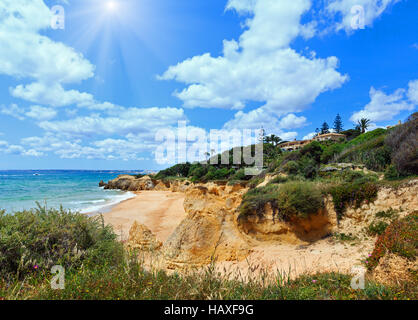 Estate sunshiny Atlantic costa rocciosa vista con casa sulla costa e alla spiaggia di sabbia (Albufeira periferia, Algarve, Portogallo). Foto Stock