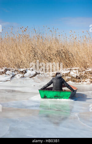 L'inverno. L'uomo in barca sul ghiaccio. Foto Stock