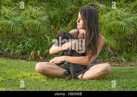 Ragazza adolescente con cucciolo sul prato Foto Stock