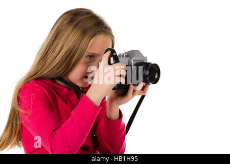 Ragazza giovane di guardare attraverso il mirino di un vintage fotocamera reflex isolato su uno sfondo bianco Foto Stock