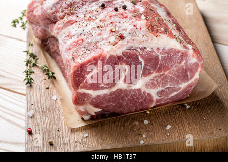 Foto di carne cruda. Collo di maiale con erbe aromatiche Foto Stock