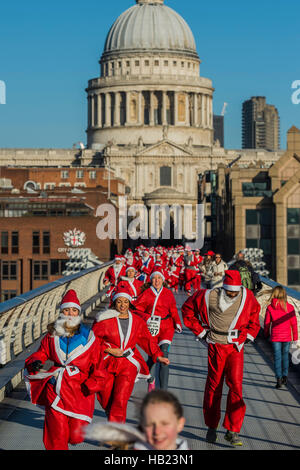 Londra, Regno Unito. 4° dic, 2016. La gara inizia di fronte alla cattedrale di San Paolo e le teste dritto oltre il Millennium Bridge - migliaia di corridori di tutte le età in santa tute e altri costumi natalizi eseguiti attraverso la città di Londra per beneficenza e per il divertimento. Londra 30 Nov 2016 Credit: Guy Bell/Alamy Live News Foto Stock