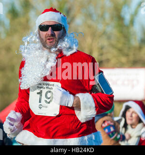 Londra, Regno Unito. Il 4 dicembre 2016. Guide di scorrimento in costumi di festa prendere parte alla Santa Dash in Cassiobury Park a Watford, raccolta di fondi per Mencap, una carità sostiene le persone con difficoltà di apprendimento e le loro famiglie. Questo evento è uno dei tanti Santa-ispirato le gare che si svolge oggi in tutta Londra la raccolta di fondi per una buona causa. Credito: Stephen Chung / Alamy Live News Foto Stock