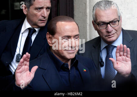 Silvio Berlusconi, con uno stand per sondaggi per segnare il suo voto al referendum sulla riforma costituzionale Foto Stock