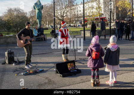 Londra, Regno Unito. 4° dic, 2016. Il sole e il freddo inverno del turista a guardare la gente buskers musicista di strada in Marble Arch il 4 dicembre 2016, Londra, Regno Unito. Credito: Vedere Li/Alamy Live News Foto Stock