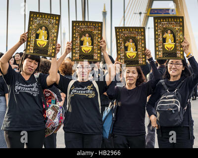 Bangkok, Bangkok, Thailandia. 5 Dic, 2016. Le donne ricoprono un ritratto della fine del Re di Thailandia dopo una cerimonia in onore di Sua Maestà Bhumibol sul ponte. Decine di migliaia di Thais raccolte sul ponte Bhumibol a Bangkok lunedì a piangere la morte di Bhumibol Adulyadej, il defunto Re della Thailandia. Il re è morto il Ott 13 dopo una lunga degenza. Il 5 dicembre è il suo compleanno e una festività nazionale in Thailandia. Il ponte è chiamato dopo il Re defunto, che ha autorizzato la sua costruzione. 990 i monaci buddisti hanno partecipato a un merito speciale rendendo cerimonia sul ponte. (Credito Immagine: © Jack Foto Stock