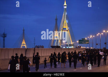 Bangkok, Tailandia. 5 Dic, 2016. Ben wishers fanno la loro strada prima dell'alba per frequentare un merito-making cerimonia per il defunto Re Bhumibol Adulyadej a Bangkok, Thailandia, Dicembre 5, 2016. Oltre ventimila persone si sono riunite a Bangkok è Bhumibol ponte per frequentare un merito-making cerimonia di 89esimo compleanno anniversario della Thailandia del compianto Re Bhumibol Adulyadej il lunedì mattina. Credito: Li Mangmang/Xinhua/Alamy Live News Foto Stock